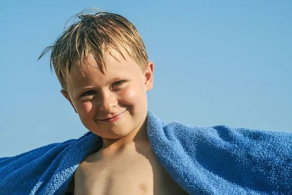 Criança sorridente com towl na praia — Fotografia de Stock