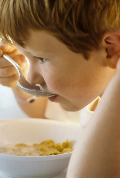 Schattige jonge jongen heeft zijn ontbijt — Stockfoto
