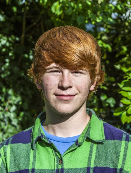 Portret van aantrekkelijke lachende jongen in de tuin — Stockfoto