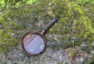 yosunlu taş zemin üzerine eski demir pan