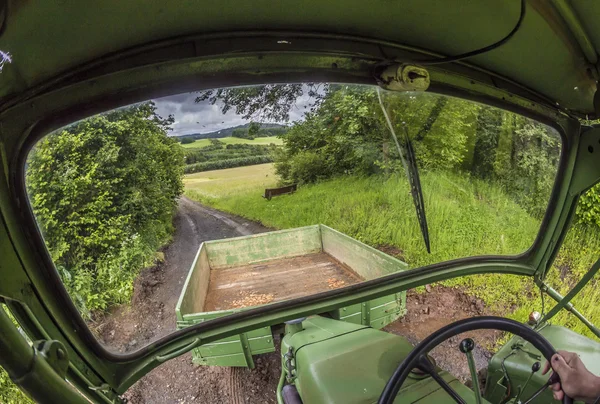 Traktor på en liten väg mellan fält — Stockfoto