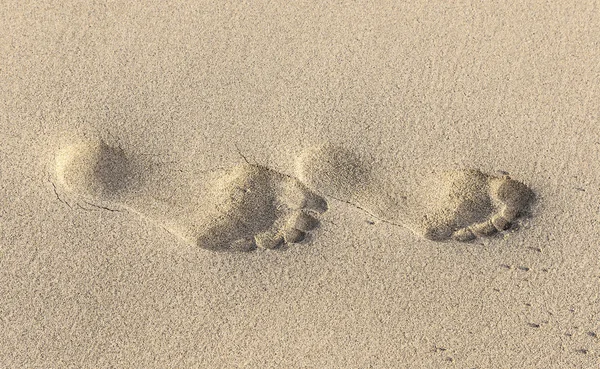 Voetafdrukken op geel zand — Stockfoto