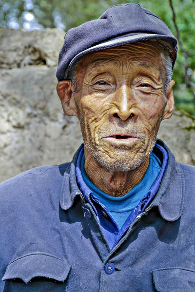 Old farmer in traditional blue working class uniform — Stock Photo, Image