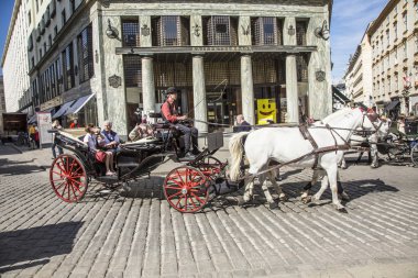 Traditional horse riding in a Fiaker through the city center in  clipart