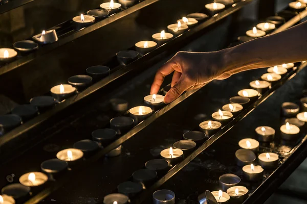 Свечи и рука, кладущая новую свечу — стоковое фото