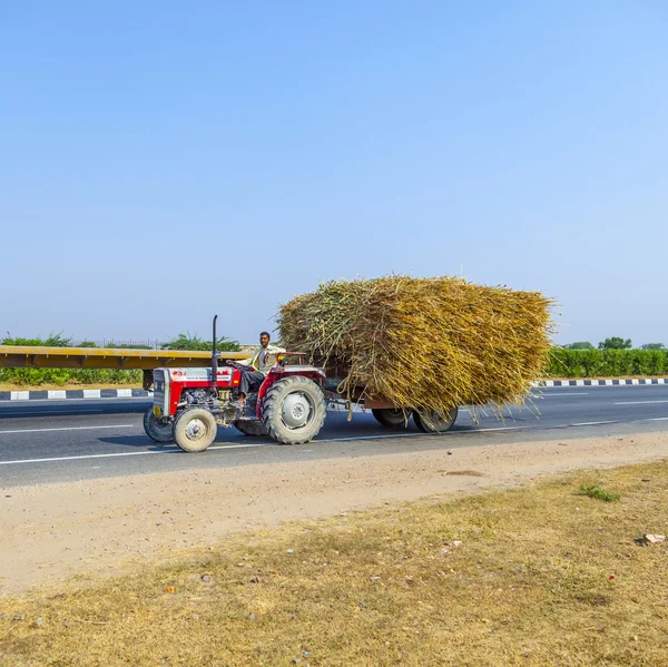 Trasporto di paglia con trattore su strada di campagna — Foto Stock