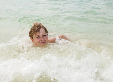 kahverengi saçlı genç çocuk yüzme sahiptir