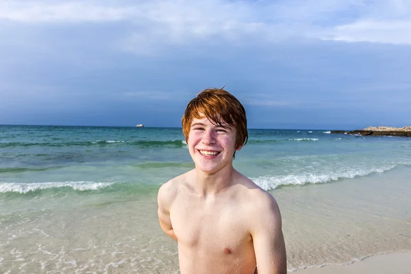 Ragazzo felice con i capelli rossi alla bella spiaggia — Foto Stock