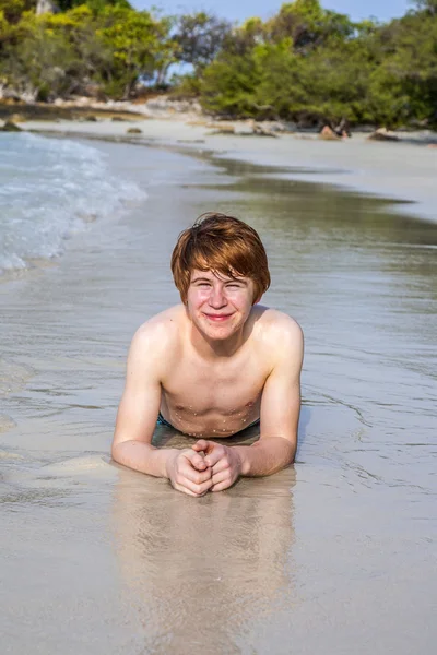 Хлопчик з рудим волоссям насолоджується красивим пляжем — стокове фото