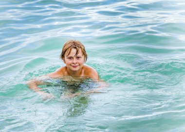 Çocuk okyanusta yüzüyor