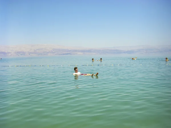 Les gens flottant sur l'eau dans la mer Morte Israël — Photo