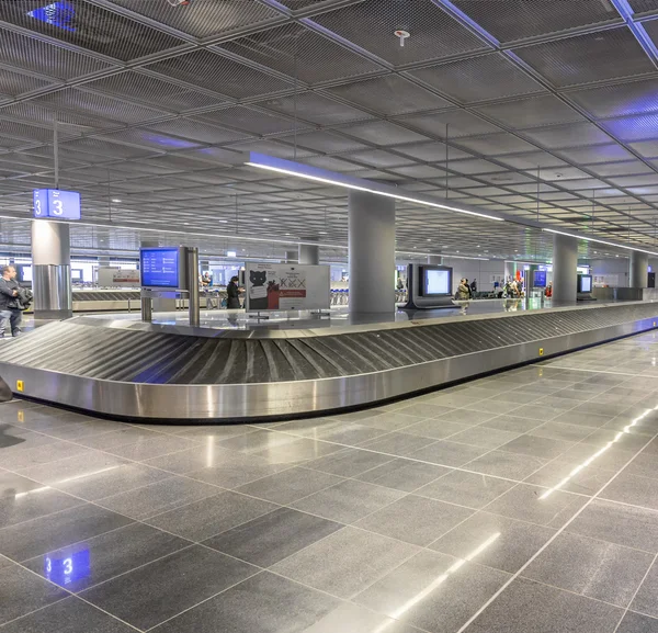 As pessoas esperam por suas malas no cinto de bagagem no aeroporto de Frankfurt — Fotografia de Stock