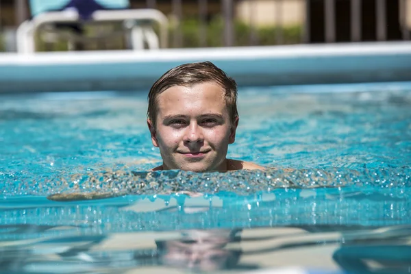 Boy enjoys swimming in the outdoor  pool — Stock Photo, Image
