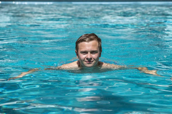 Menino gosta de nadar na piscina exterior — Fotografia de Stock