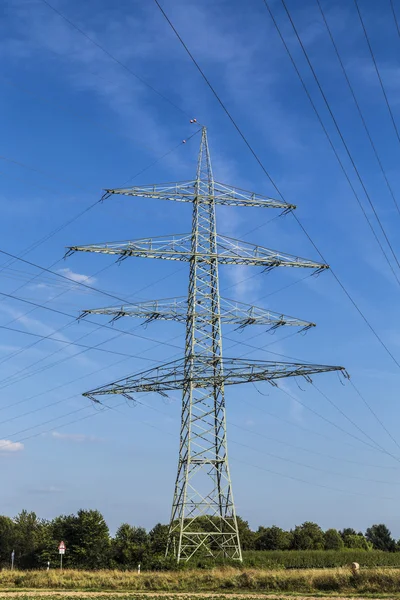 Pilones eléctricos que transportan electricidad a través de alta tensión ca — Foto de Stock