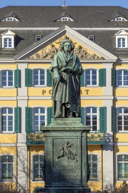 Ünlü besteci Ludwig van Beethoven 'ın heykeli. Arka planda, Almanya' nın Bonn kentindeki Munsterplatz 'da bulunan güzel eski postane binası..