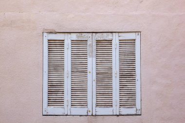 Ahşap pencereli ve arka planda boyalı eski bir ev.