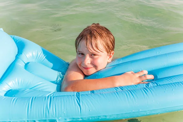Uśmiechnięty Chłopiec Lubi Pływać Materacem Czystej Wodzie — Zdjęcie stockowe