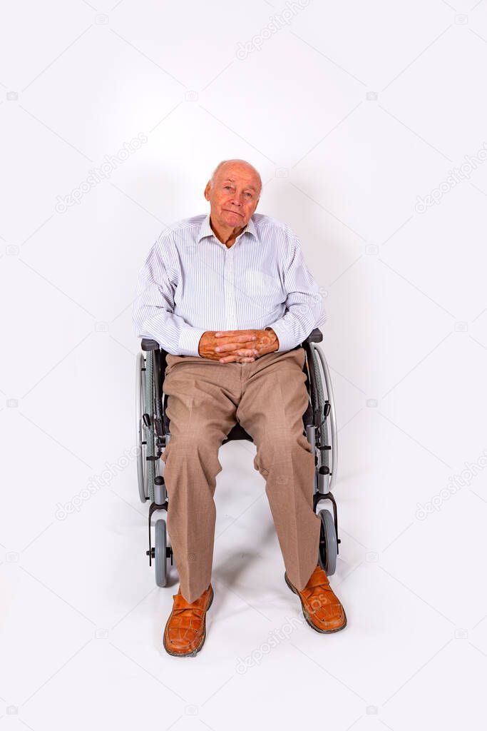 happy elderly man sits smiling in his wheelchair