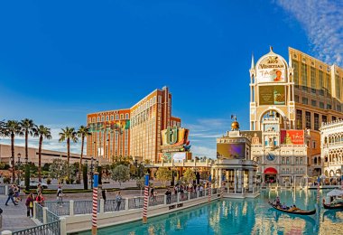 Las Vegas, ABD - 9 Mart 2019: The Venedikli ünlü otel Gondolda insanlar ve arka planda kumarhane hazine adası.