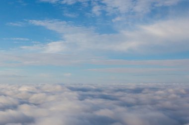 Mavi gökyüzündeki yumuşak bulutlar harmonik bir arkaplan verir