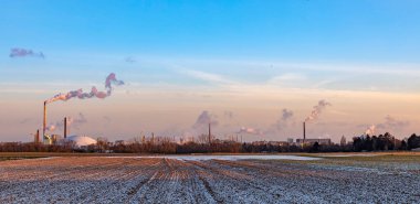 Geceyarısı Frankfurt 'ta tarlalar ve kışın tüten bacalarla sanayi kompleksi