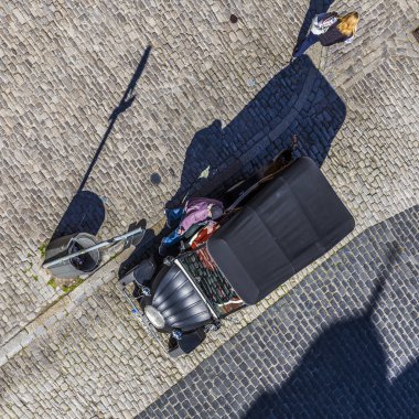 ROTHENBURG, GERMANY - 19 Nisan 2015: Rehber, Rothenburg, Almanya 'da eski model bir arabayla turistleri bekliyor. Ortaçağ kasabası her yıl 2 milyondan fazla ziyaretçi çekiyor..