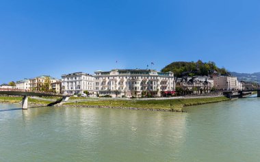 Salzburg, Avusturya - 21 Nisan 2015: Salzburg, Avusturya 'daki Salzach Nehri' nde Otel Sacher. Otel 1863-1866 yılları arasında otelci ve usta müteahhit Carl Freiherr tarafından inşa edilmiştir..
