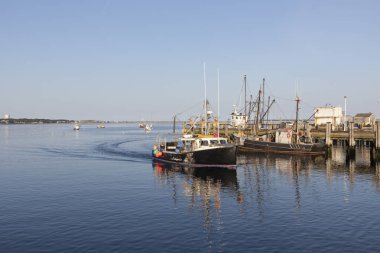 romantic view to ships from Pier in Provincetown in sunset clipart