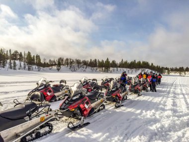 Inari, Finlandiya - 2 Nisan 2015: kar motosikletli insanlar Inari, Finlandiya 'da turneye çıktılar. Ivalo ve Inari bölgelerindeki kar mobil rotaları toplam 65 km 'yi kapsıyor ve yerel yetkililer tarafından korunuyor..