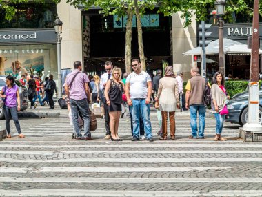 Paris, Fransa - 12 Haziran 2015: Paris 'in göbeğindeki Champs de Elysees kavşağında yayalar için trafik ışıklarında insanlar karşıdan karşıya geçiyor..
