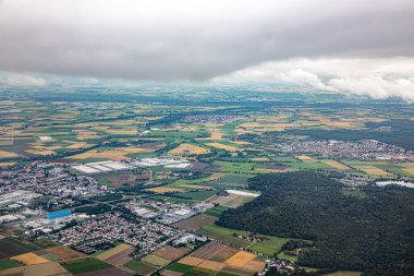 Gross Gerau 'nun Hesse' deki anteninde bulutlu gökyüzü ile tarım ve sanayi üretimi