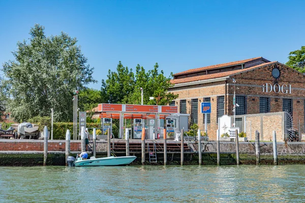 Murano, Italy - July 1, 2021: petrol station at the canal in Burano, the island of venice with historic glass blowing industry.