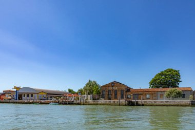Murano, Italy - July 1, 2021: petrol station at the canal in Burano, the island of venice with historic glass blowing industry.