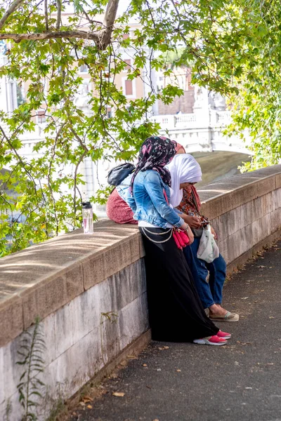 ローマ イタリア 2021年8月2日 スカーフを持つイスラム教徒の女性は ティバー遊歩道に沿って散歩を楽しみ ローマでメッセージを送信するために携帯電話を使用しています — ストック写真