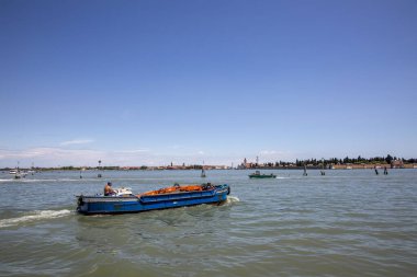 Venedik, İtalya - 2 Temmuz 2021: İşçi vinci ile birlikte Venedik 'teki lagünün yanından geçen şantiyeye gidiyor..