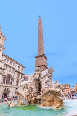 Roma, İtalya - 2 Ağustos 2021: İnsanlar arka planda cupidleri ve diğer heykelleri olan Piazza Navona 'nın kuzey ucunda yer alan Fiumi çeşmesini ziyaret ediyor; Roma, İtalya.