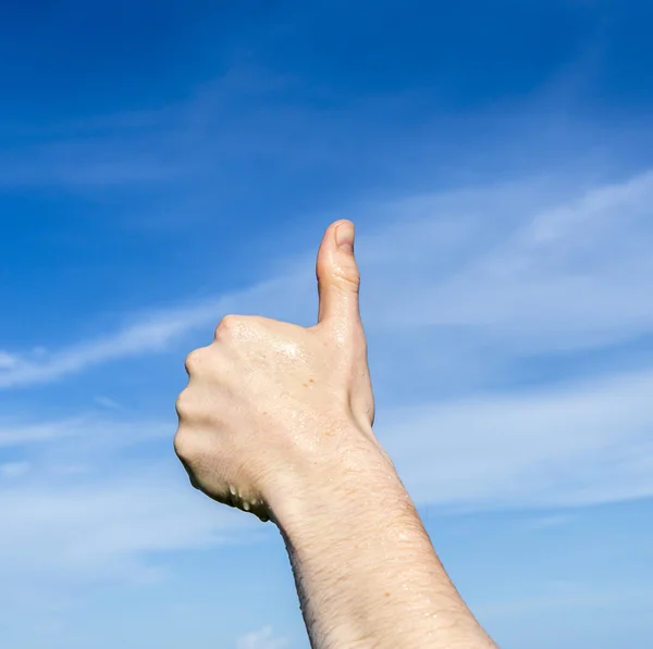 Thumbs up sign under blue sky — Stock Photo, Image