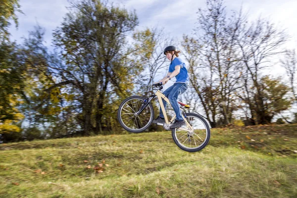 Jongen springt over een helling met zijn vuil fiets — Stockfoto