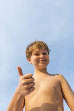 mutlu fingersign başparmak-up gülümseyen genç çocuk verir