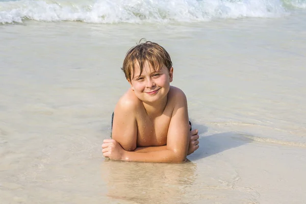 Menino na praia gosta da praia arenosa — Fotografia de Stock