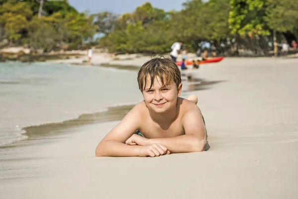 Хлопчик на пляжі насолоджується піщаним пляжем — стокове фото