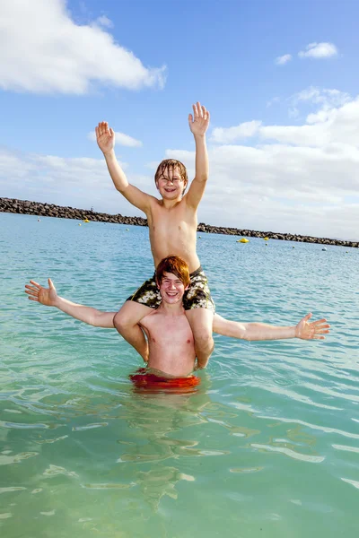 Boys having fun in the clear sea — Stock Photo, Image