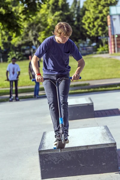 Boy has fun riding his push scooter — Stock Photo, Image