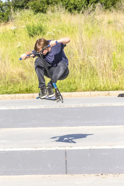 Boy has fun riding his push scooter — Stock Photo, Image