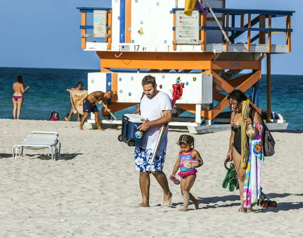 People enjoy the beach next to a lifeguard tower — Stock Photo, Image