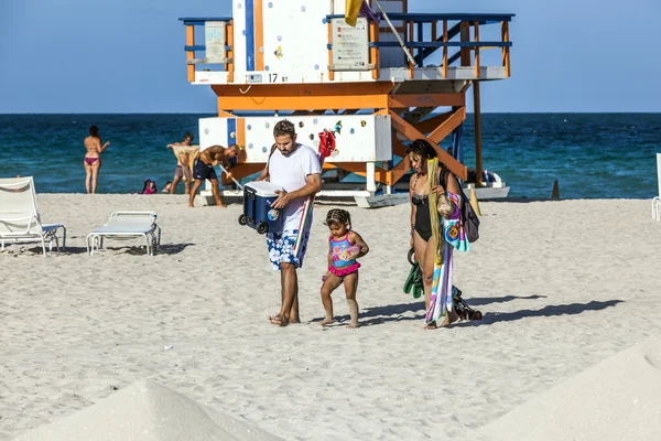 People enjoy the beach next to a lifeguard tower — Stock Photo, Image