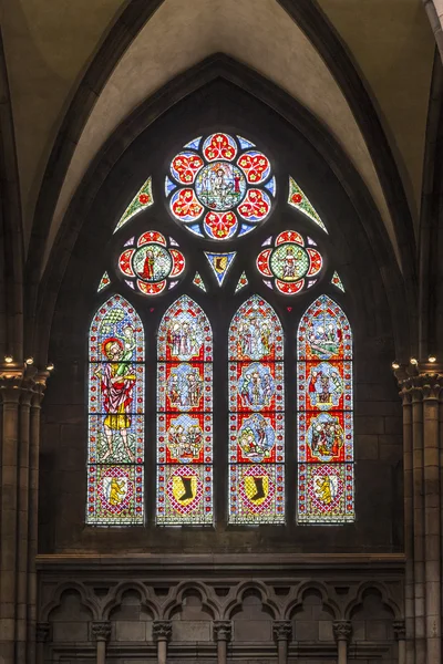 Beautiful windows of the minster show religious scenes from the — Stock Photo, Image