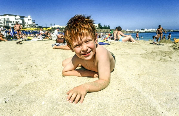 Мальчик наслаждается сумасшествием на пляже — стоковое фото