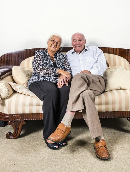 高级夫妇坐在沙发上的爱情 — 图库照片
